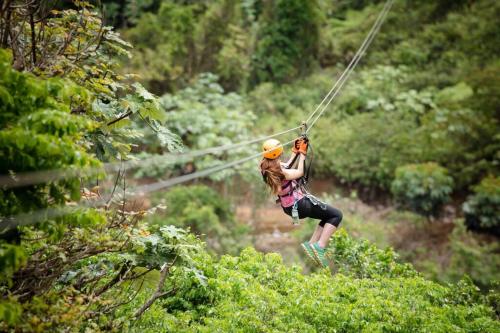 a woman on a zip line in the jungle at Paradise Coast PR - Condo in Isabela