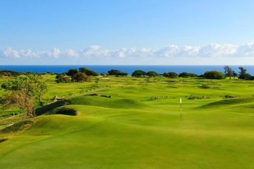 a golf course with the ocean in the background at Paradise Coast PR - Condo in Isabela
