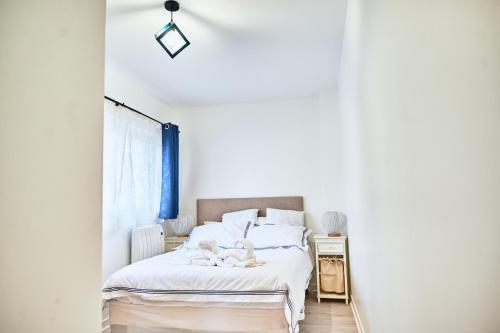 1 dormitorio con cama blanca y ventana en Appartement moderne et lumineux - Centre ville Creil, en Creil