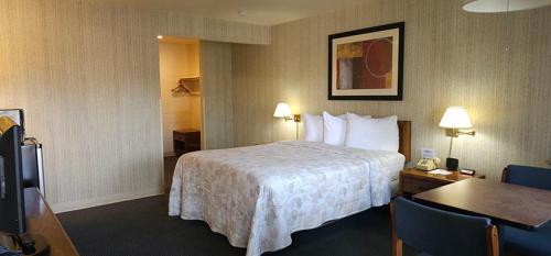 a hotel room with a bed and a desk with a table at Orland Inn in Orland