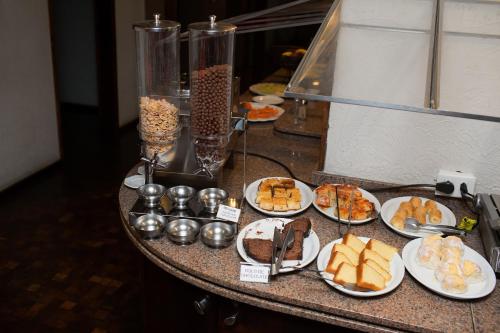 a table with several plates of food on it at Rede Andrade São Francisco in Curitiba