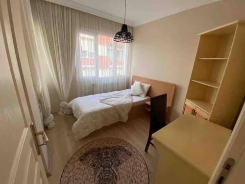 niewielka sypialnia z łóżkiem i oknem w obiekcie Ferah ve şık cosy daire w mieście Konak