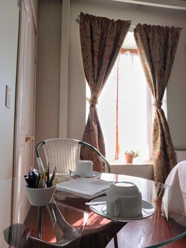 a dining room table with a chair and a window at Casona Patrimonial Cobquecura Hotel Boutique in Cobquecura