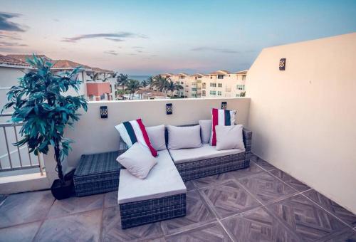 a balcony with two couches and a potted plant at Paradise Coast PR - Vista Mar in Isabela