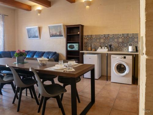 a kitchen and dining room with a table and a laundry room at Moonshine Villa in Nadur