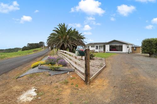 uma casa com uma cerca e flores ao lado de uma estrada em Apartment 1 em Auckland