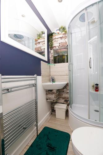 a bathroom with a shower toilet and a sink at Harmony Haven - Ocean Drive Suite in Nottingham