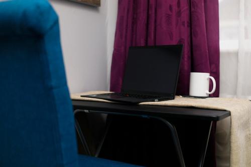 einen Laptop auf einem Tisch mit einer Kaffeetasse in der Unterkunft Harmony Haven - Ocean Drive Suite in Nottingham