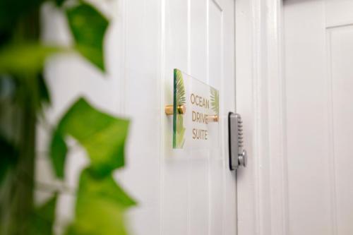 ein Türknauf mit einem Schild an einer weißen Tür in der Unterkunft Harmony Haven - Ocean Drive Suite in Nottingham