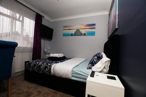 ein Schlafzimmer mit einem Bett und einem Bild an der Wand in der Unterkunft Harmony Haven - Ocean Drive Suite in Nottingham