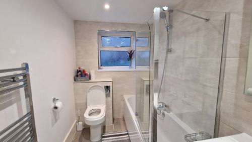 a bathroom with a toilet and a shower at 3 Bedroom House in Rochester Strood with Wifi and Netflix Walking distance to Strood Station in Wainscot