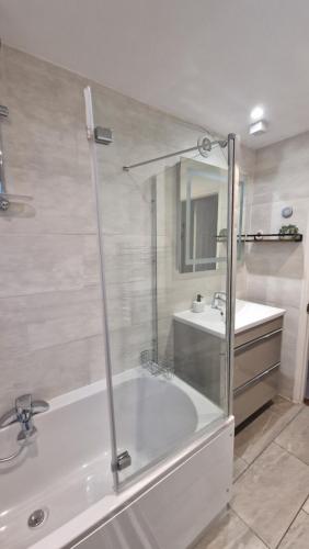 a bathroom with a shower and a tub and a sink at 3 Bedroom House in Rochester Strood with Wifi and Netflix Walking distance to Strood Station in Wainscot