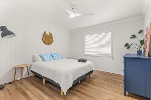 1 dormitorio con cama, mesa y ventana en SeaSalt72 by Experience Jervis Bay, en Erowal Bay