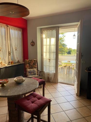 un soggiorno con tavolo, sedie e vista di Rouge Cottage nel Roero a Sanfrè