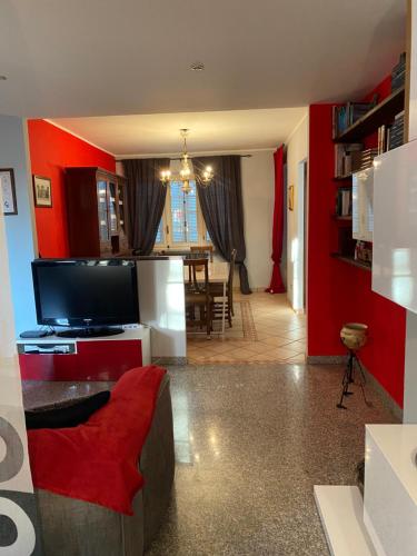a living room with a red accent wall and a television at Rouge Cottage nel Roero in Sanfrè