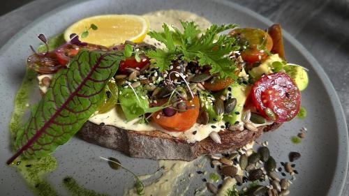 a plate with a piece of bread with vegetables on it at Essence Peregian Beach Resort - Lily 4 Bedroom Luxury Home with Private Pool in Peregian Beach