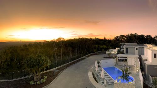 ペレジアンビーチにあるEssence Peregian Beach Resort - Lily 4 Bedroom Luxury Home with Private Poolの夕日を背景にした家の景色