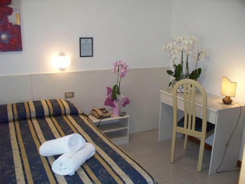 リド・ディ・イエゾロにあるHotel Portofinoのベッドルーム1室(ベッド1台、デスク、タオル付)