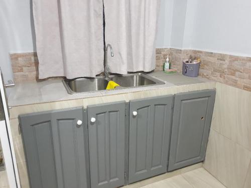 a kitchen counter with a sink and a window at Rooftop Inn Apartments in Piarco