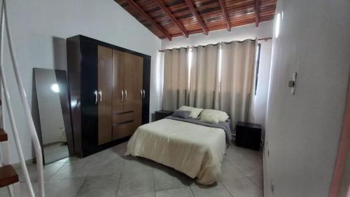 a bedroom with a bed and a wooden cabinet at Hermoso Apartamento tipo Loft en Lecheria Anzoátegui in El Morro de Barcelona