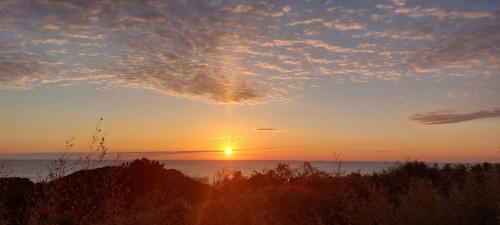 a sunset over the water with the sun in the sky at Tsushima Izuhara Pension in Tsushima