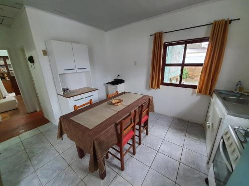 a kitchen with a wooden table in a room at Casa no Centro - Perto do mar e do rio in Tramandaí