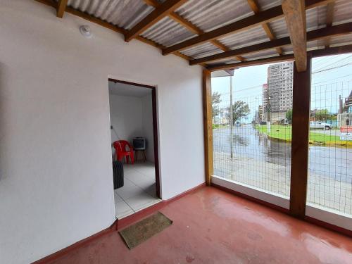 an empty room with a door open to a balcony at Casa no Centro - Perto do mar e do rio in Tramandaí