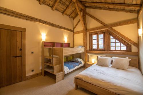 een slaapkamer met een bed en een stapelbed bij Chalet Forest - Luxueuse ferme rénovée - 12 pers in La Rivière-Enverse