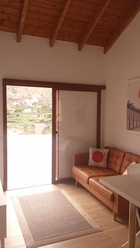 a living room with a couch and a sliding glass door at CASA EL MIRADOR DE BIBIANA in Hermigua