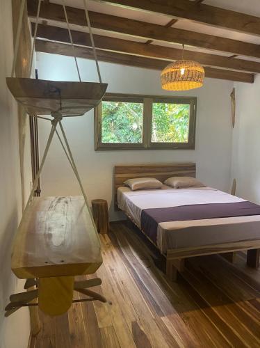 a bedroom with a bed and a wooden floor at Passion Fruit Lodge in Cahuita