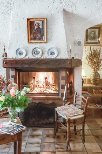 a living room with a fireplace and a table and chairs at L'Auberge du Choucas in Le Monêtier-les-Bains