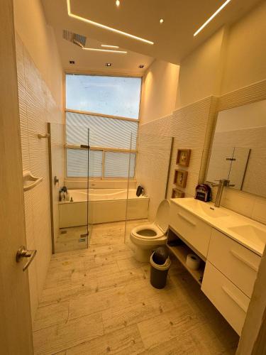 y baño con aseo, lavabo y bañera. en Cabaña la arenosa en Barranquilla