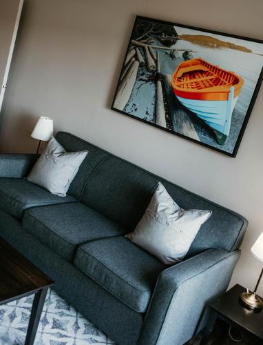 a living room with a couch and a picture of a boat at Page's Inn on Silva Bay in Gabriola