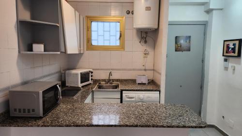 una pequeña cocina con fregadero y microondas en Miramar Nautic, en Salou