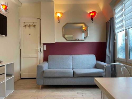 un salon avec un canapé et un miroir dans l'établissement Wonderful apartment near Arc de Triomphe 2P, à Paris