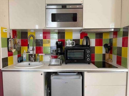 une cuisine avec un évier et un micro-ondes dans l'établissement Wonderful apartment near Arc de Triomphe 2P, à Paris