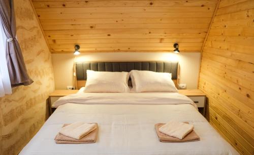 a bedroom with a bed with two towels on it at Villa Zagorka and mountain houses A, M, D in Kopaonik