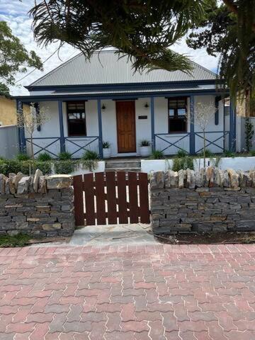 a house with a gate and a stone wall at Two roomed private suite in front of cottage in Grange