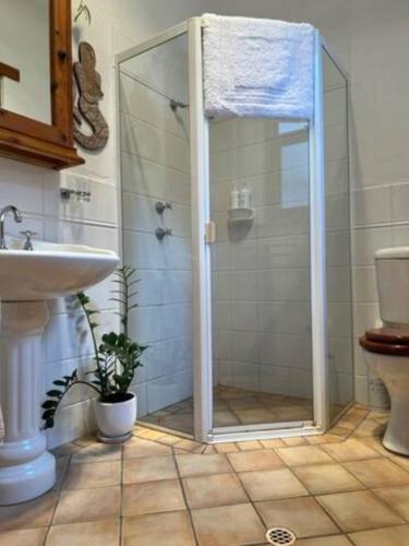 a shower with a glass door in a bathroom at Two roomed private suite in front of cottage in Grange