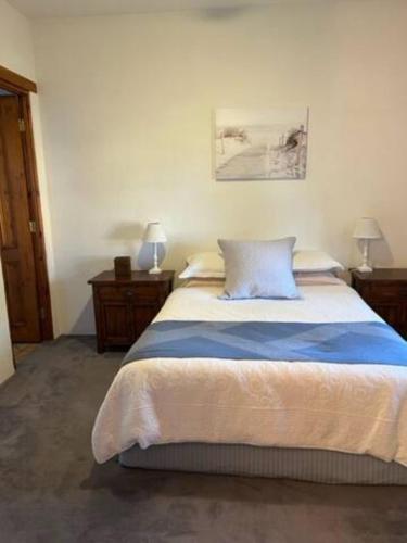 a bedroom with a large bed with a blue pillow at Two roomed private suite in front of cottage in Grange