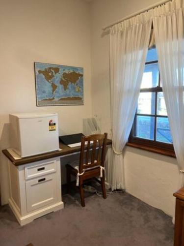 a office with a desk with a computer and a window at Two roomed private suite in front of cottage in Grange