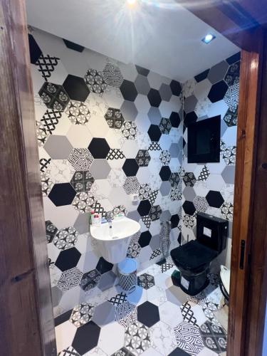 a bathroom with a black and white tiled floor at Appartement marina hammamet in Hammamet