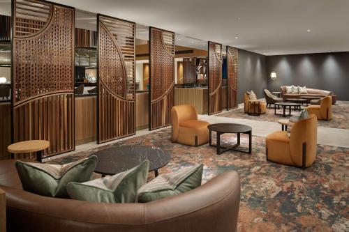 a lobby with couches and chairs and a table at Hilton London Metropole in London