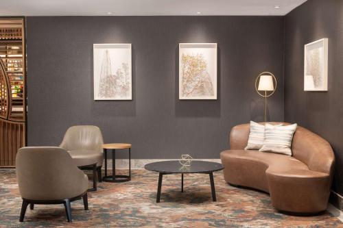 um átrio com um sofá, duas cadeiras e uma mesa em Hilton London Metropole em Londres