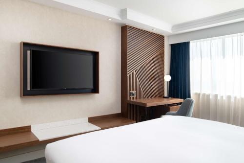 a hotel room with a bed and a flat screen tv at Hilton London Metropole in London