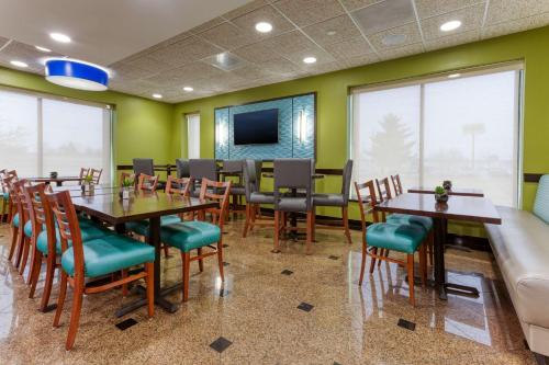 a dining room with tables and chairs and a couch at Drury Inn & Suites St. Louis Fenton in Fenton