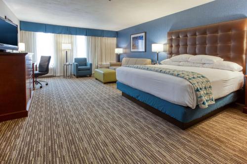 a hotel room with a large bed and a living room at Drury Inn & Suites St. Louis Fenton in Fenton