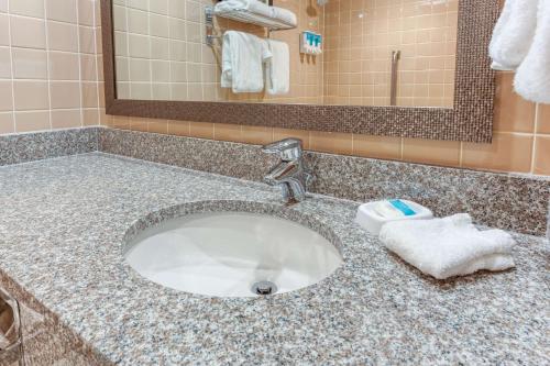 a bathroom counter with a sink with a towel at Drury Inn & Suites St. Louis Fenton in Fenton