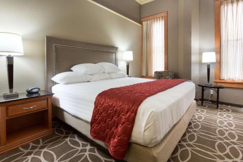 聖安東尼奧的住宿－聖安東尼奧河濱德魯利套房酒店，酒店客房设有一张大床和两盏灯。