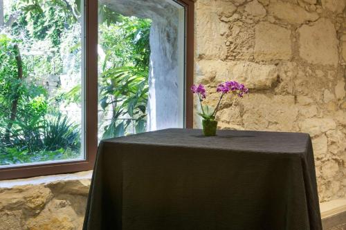 a table with a vase with purple flowers on it at Drury Inn & Suites San Antonio Riverwalk in San Antonio